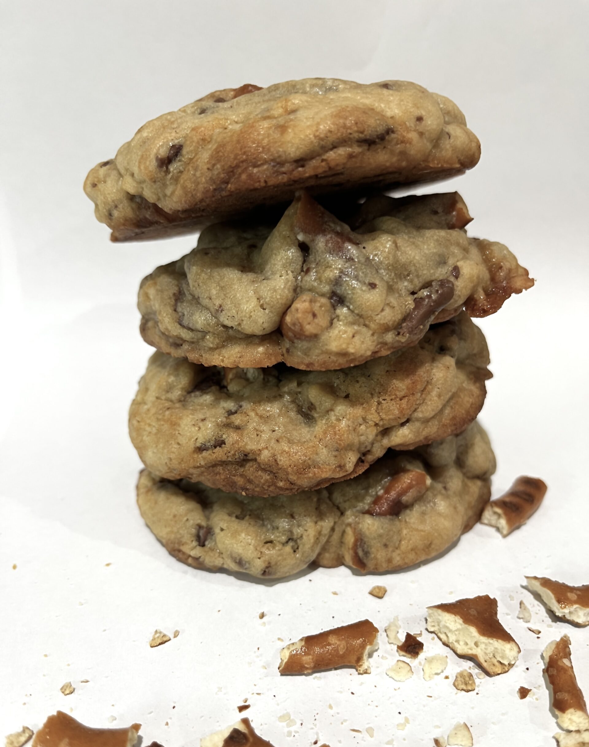 Chewy salted caramel pretzel cookie with golden brown edges, with gooey caramel bits and topped with crunchy pretzel twists and flaky sea salt
