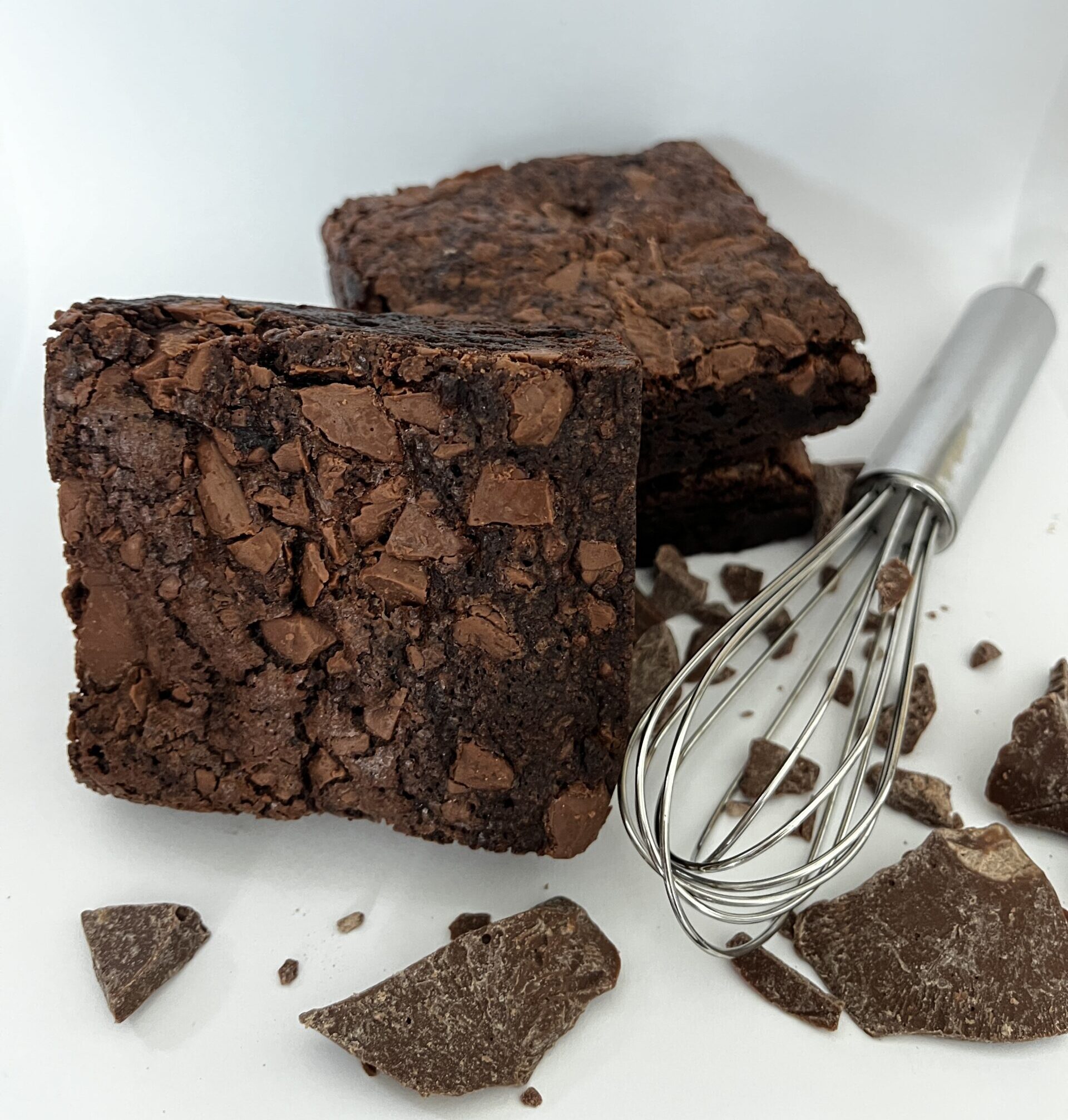 Front view of a gooey classic chocolate brownie with a fudgy, moist center and slightly crisp edges, freshly baked, topped with chocolate chunks, perfect for chocolate lovers and gourmet dessert fans.